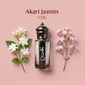 A perfume bottle labeled 'Akari Jasmin N116' centered on a soft pink background, flanked by white jasmine flowers on the left and pale pink blossoms on the right.