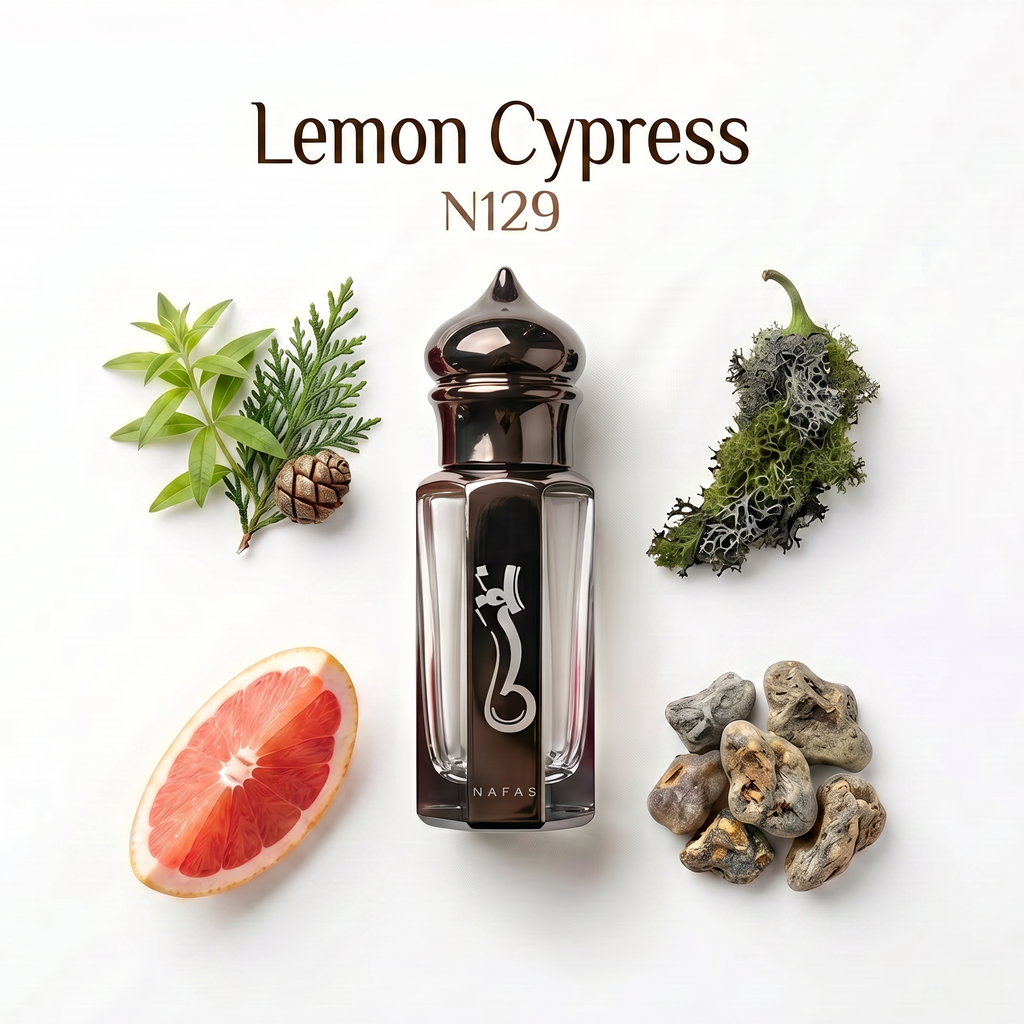 A bottle of Nafas Lemon Cypress N129 perfume is displayed on a clean white background with botanical and citrus props including a grapefruit slice, pine sprigs, a small pinecone, dried greenery, and stones. The text 'Lemon Cypress N129' is printed at the top.