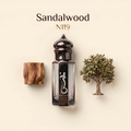 A perfume bottle labeled 'Sandalwood N119' with a dark cap, shown on a warm cream background with a wood block and a small tree prop. The bottle has a black central panel with a white snake-like logo and the word 'NABIA'.